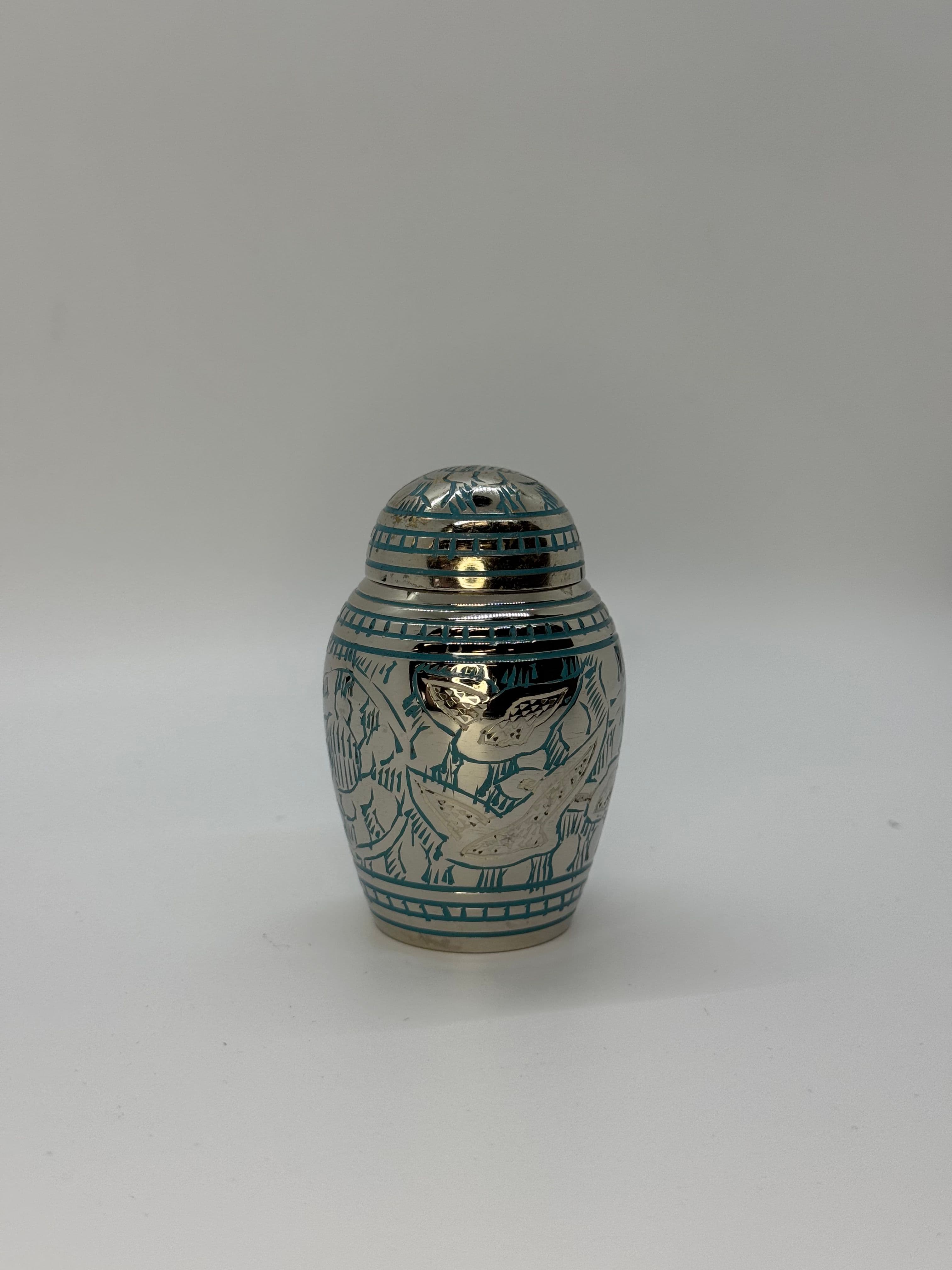 Silver color keepsake urn with blue engraving with white birds, featuring a domed top.